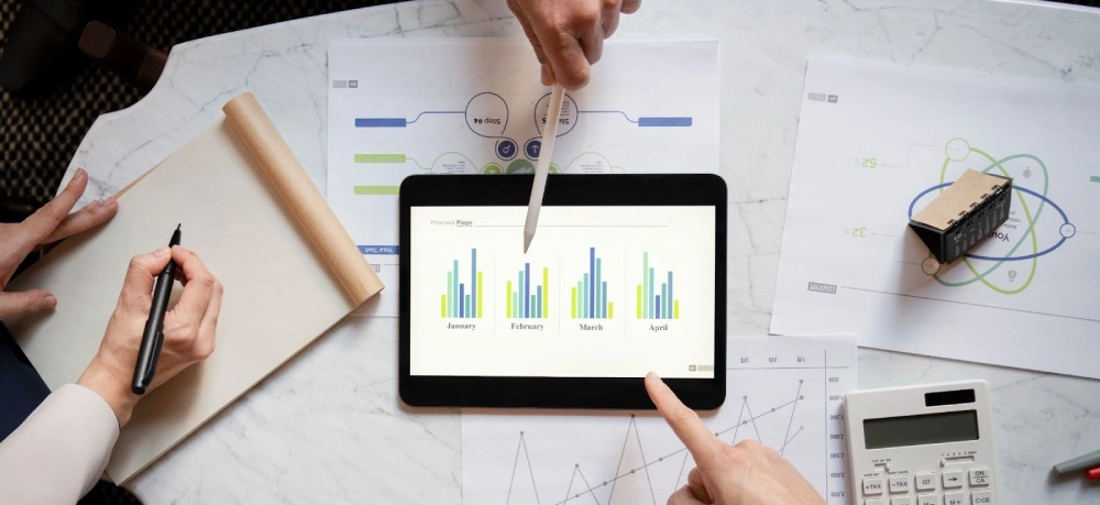 Business data analysis showing monthly performance charts on digital tablet